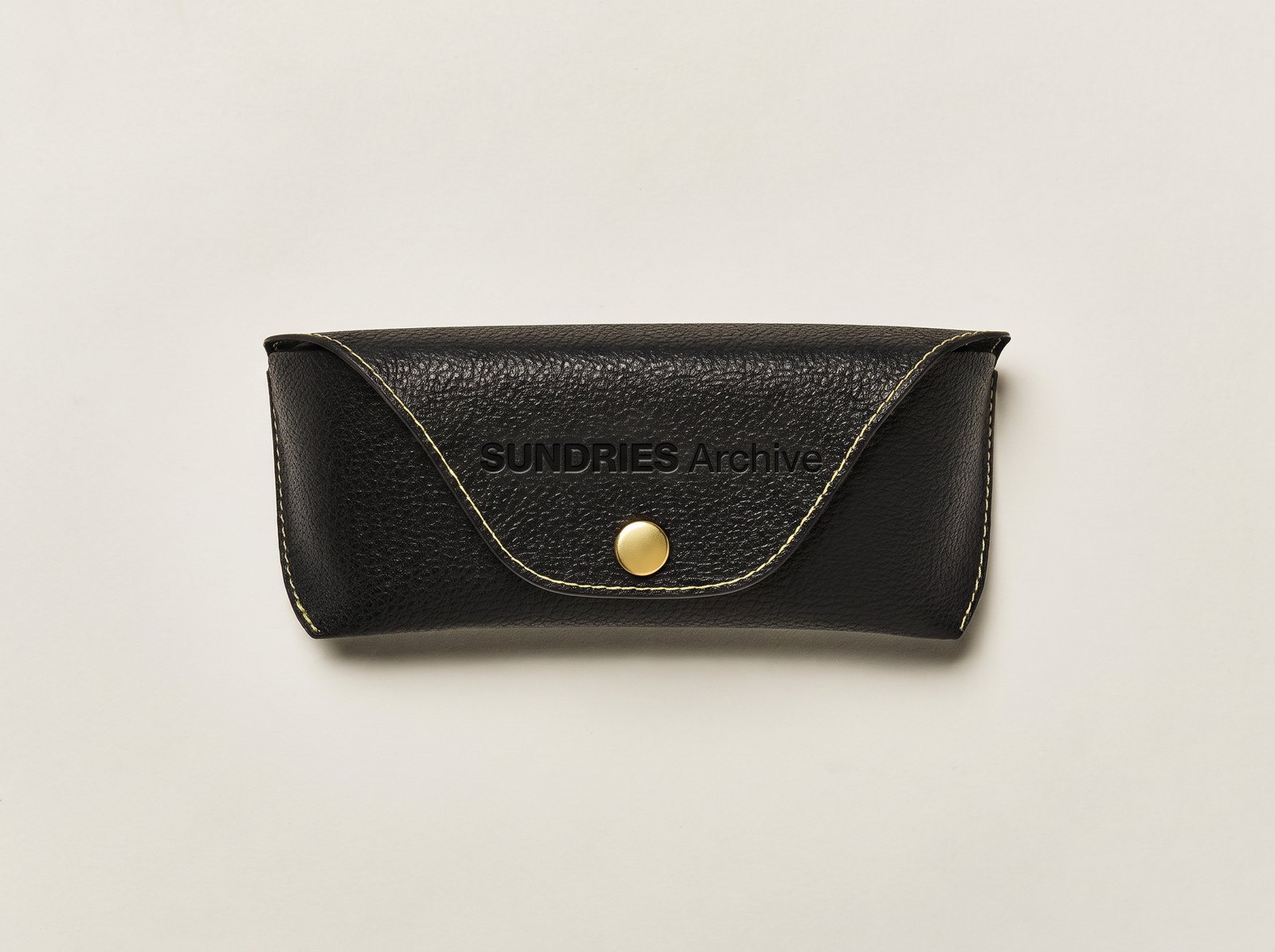 가죽 케이스에 SUNDRIES Archive를 눌러 찍은 AI 합성 예시